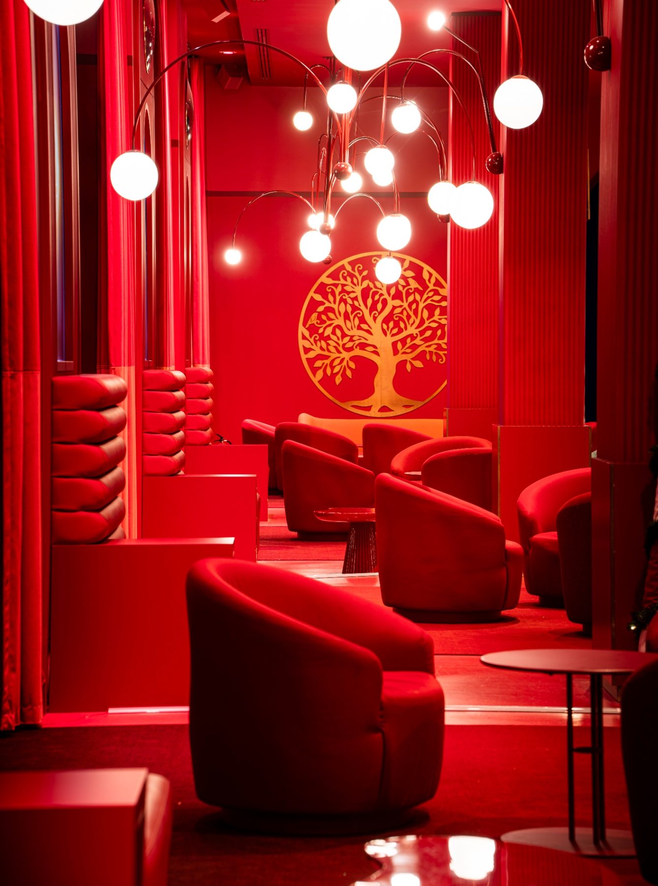 Lounge feutré aux tons rouges profonds, ambiance cinématographique