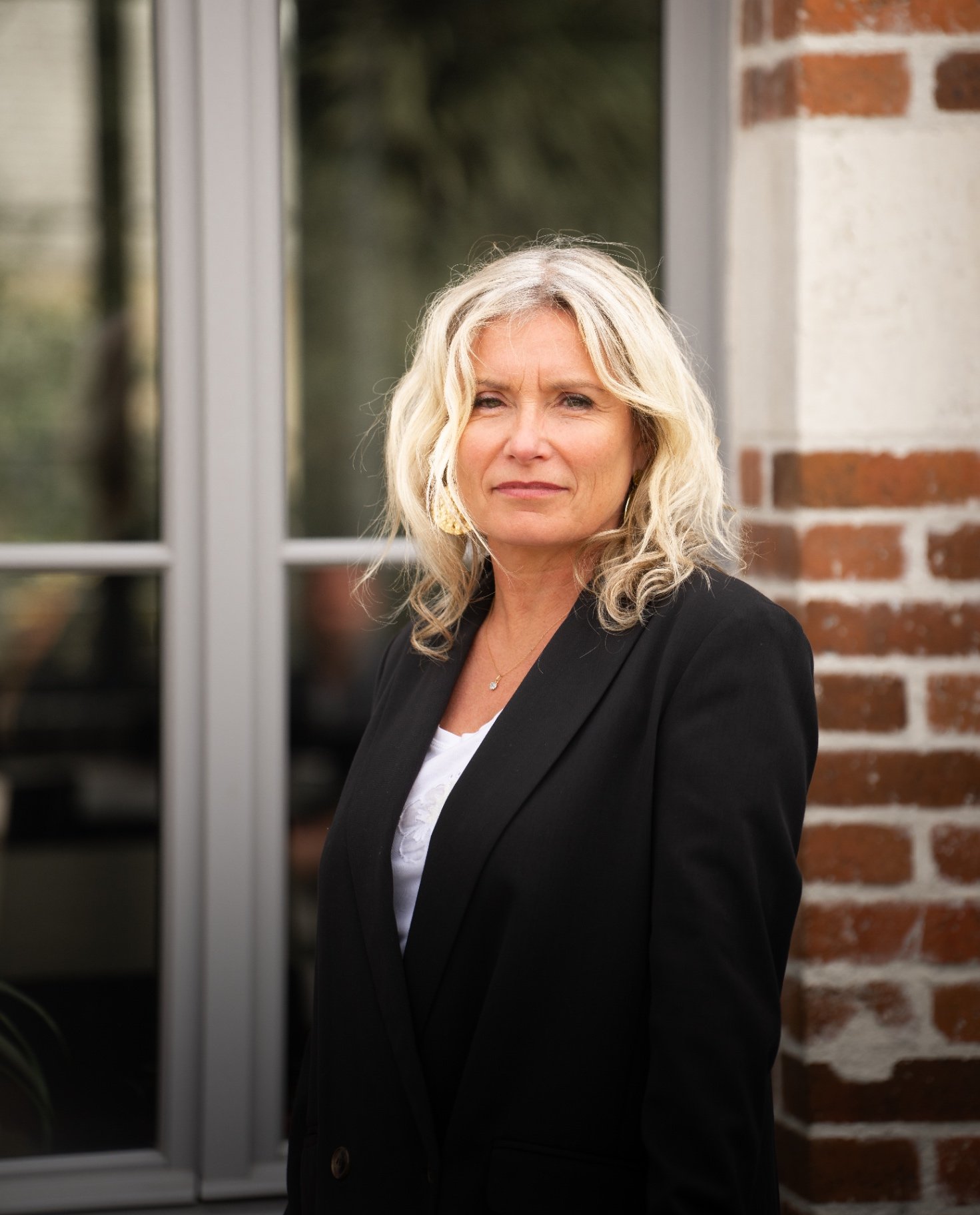 Portrait corporate d'une dirigeante devant un mur de brique