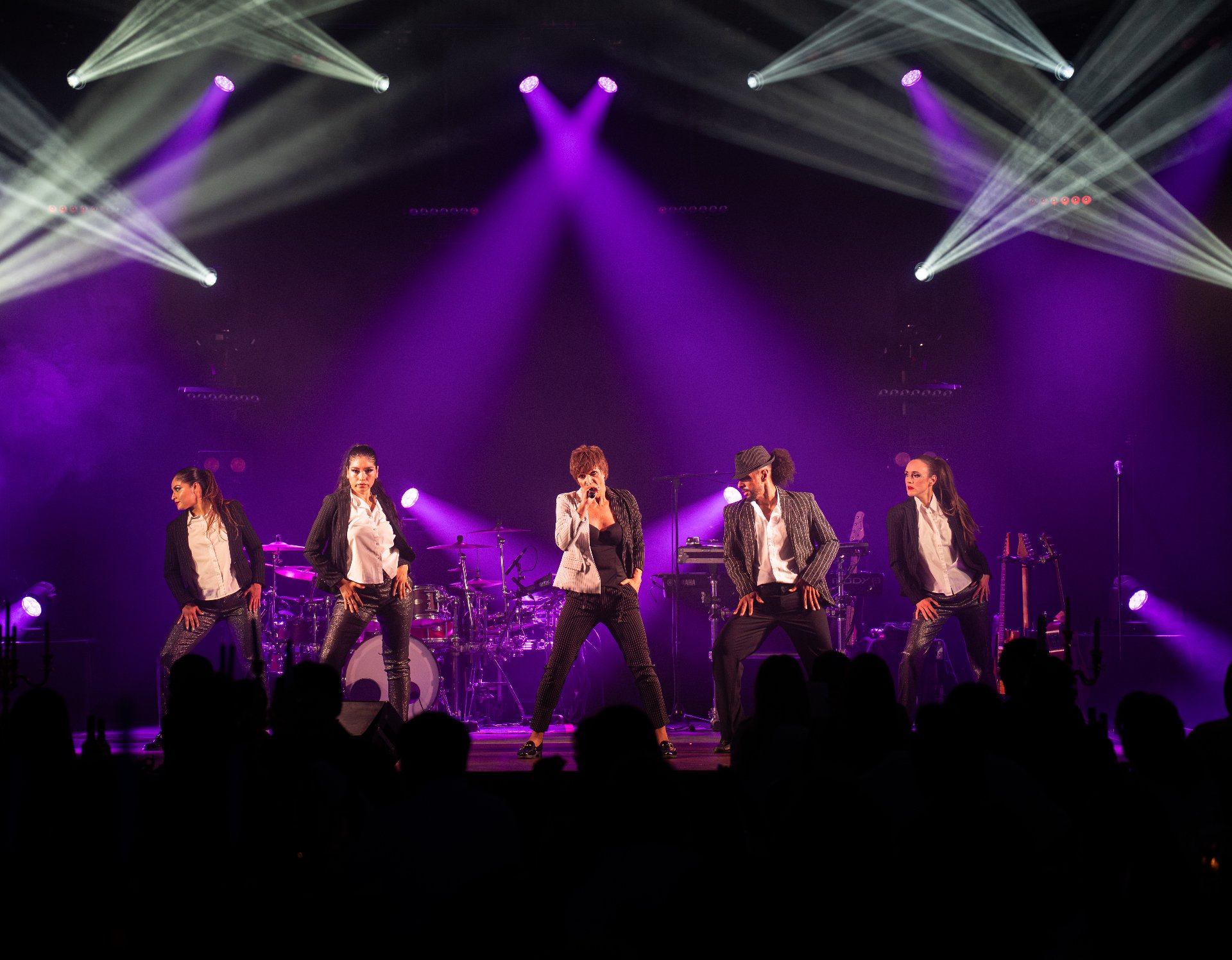 Chanteuse et danseurs sous faisceaux violets