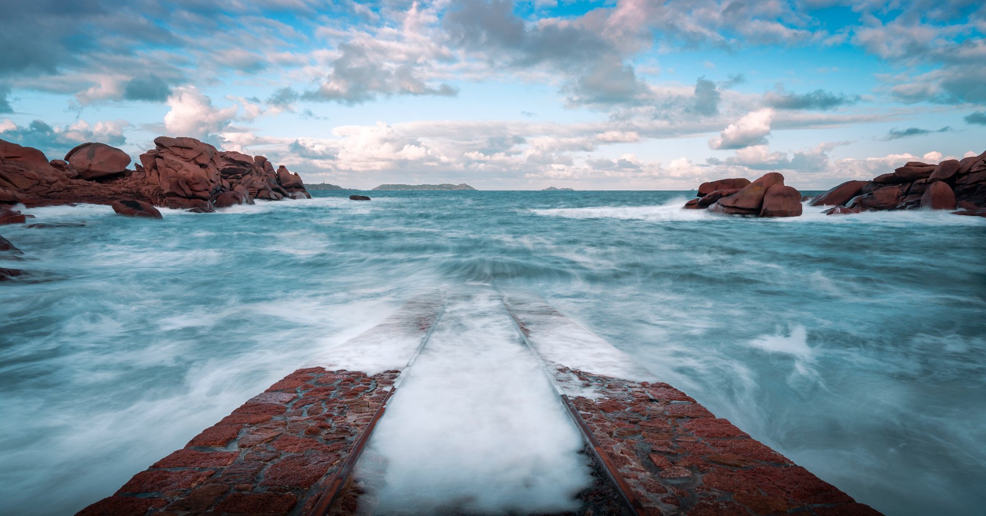 Cale de pierre battue par les vagues sur la côte de granit rose, Bretagne
