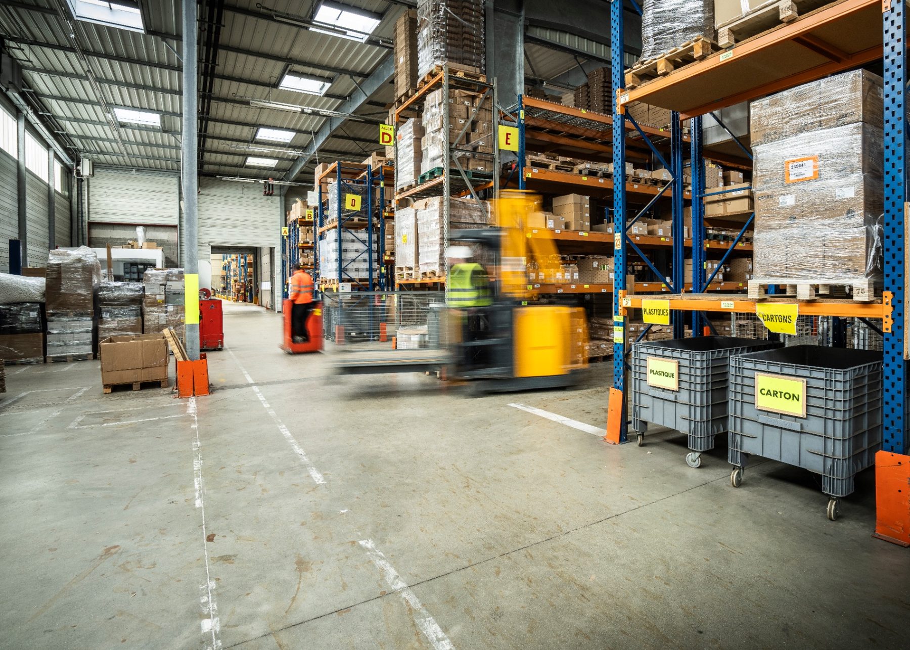 Entrepôt logistique, allées et rayonnages en mouvement