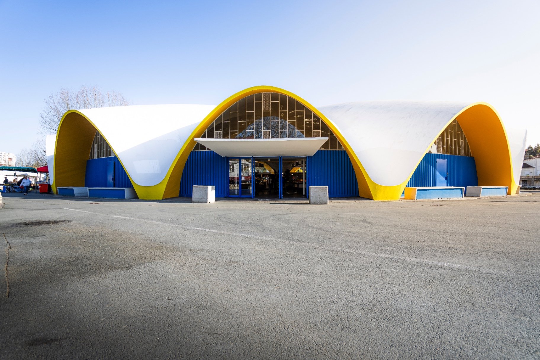 Halle de marché à l'architecture ondulée blanche et jaune
