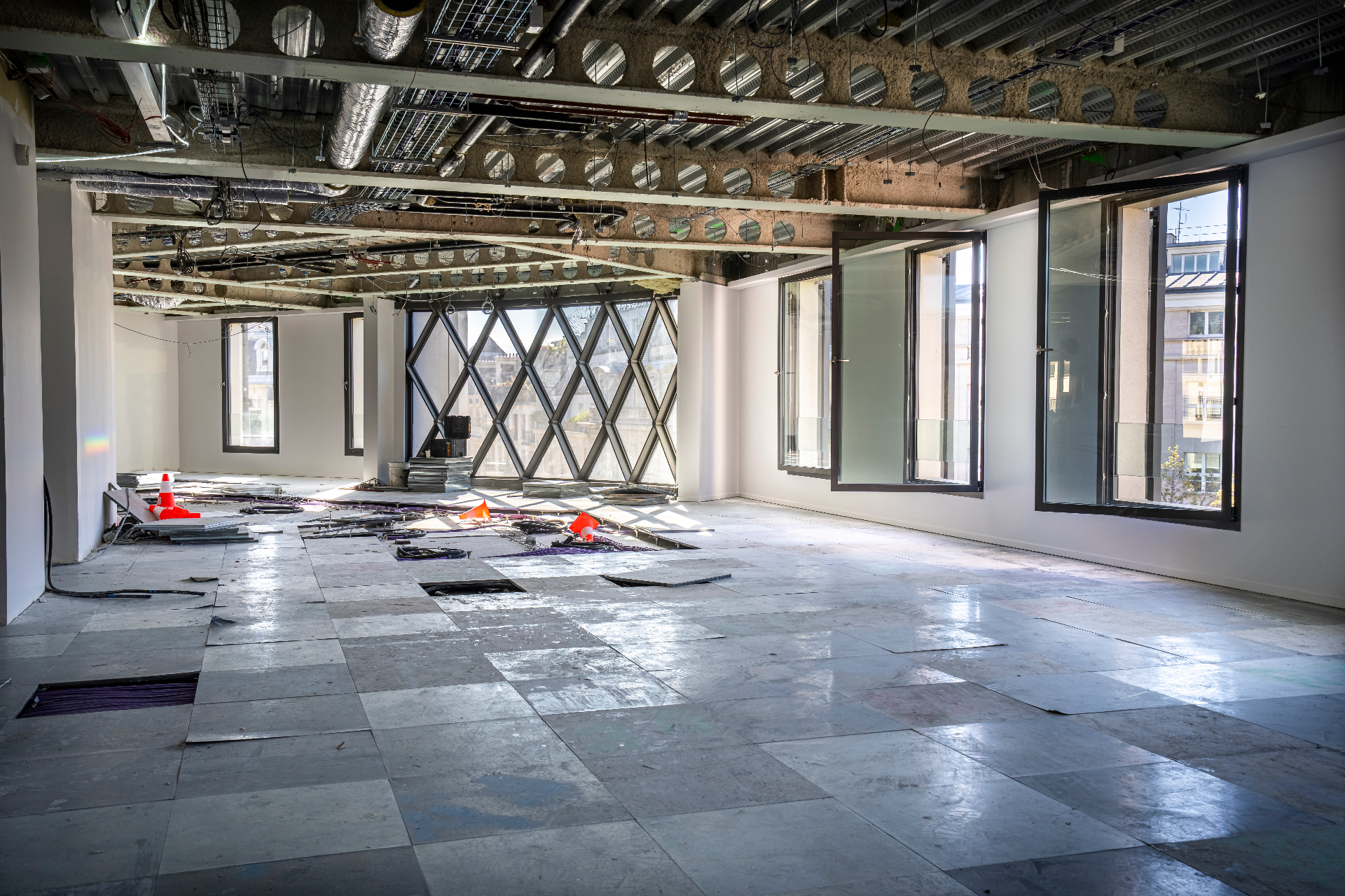 Plateau de bureaux en chantier, verrière losangée et lumière traversante