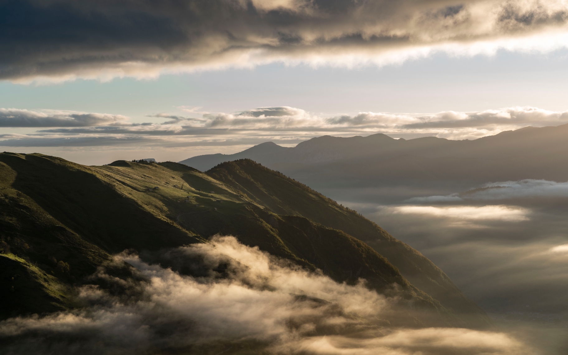 Crêtes au lever du soleil, nuages suspendus