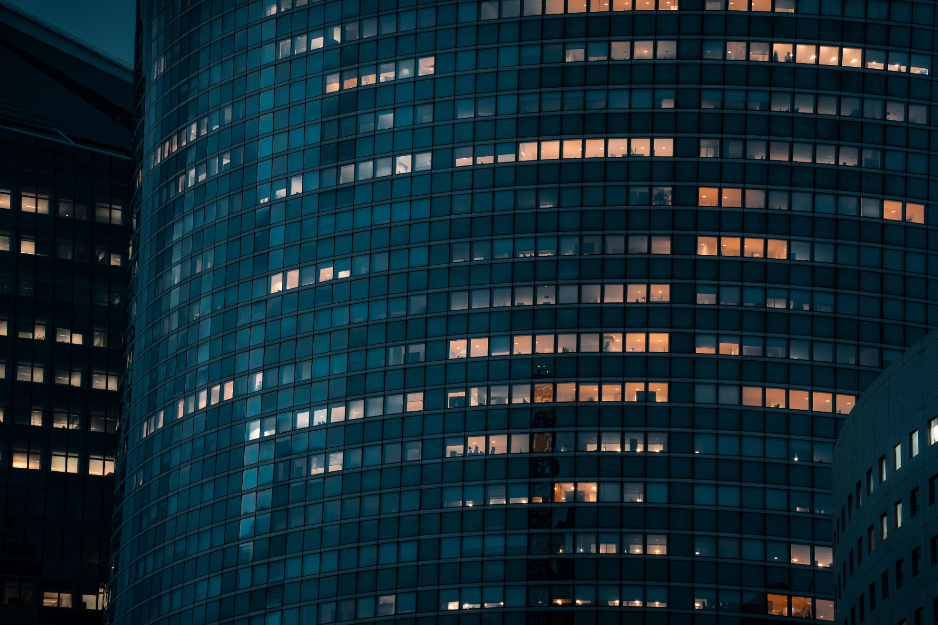 Façade courbe et fenêtres allumées à La Défense