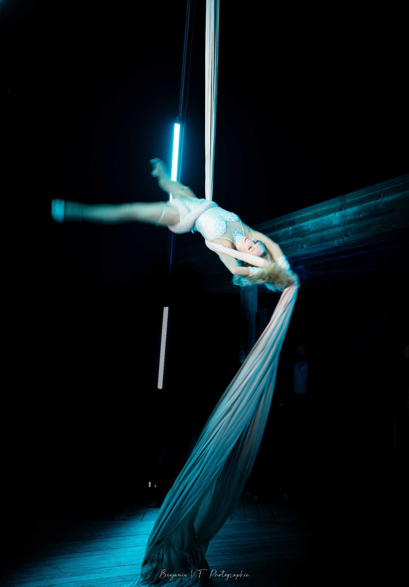 Acrobate aérienne sur tissu, éclairage bleu cinématographique